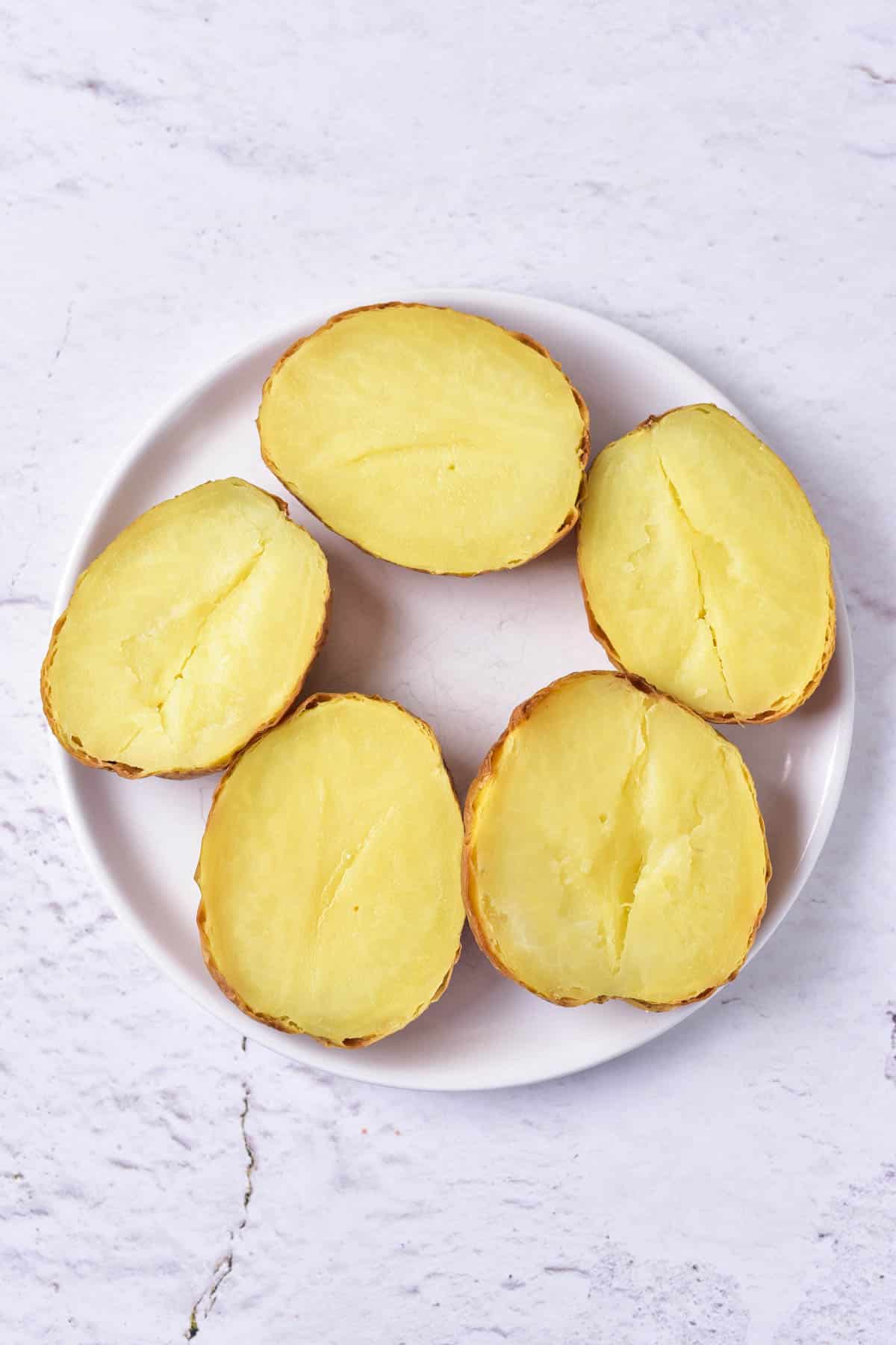 Baked potato halves on a plate.