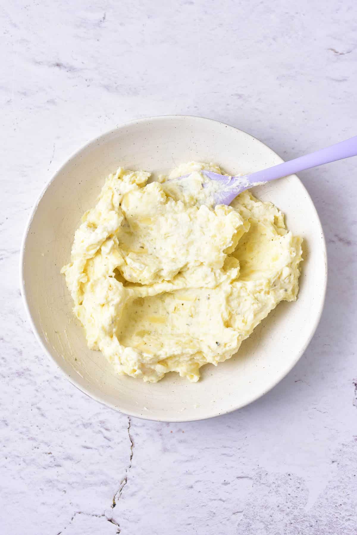 Mashed baked potatoes in a white bowl.