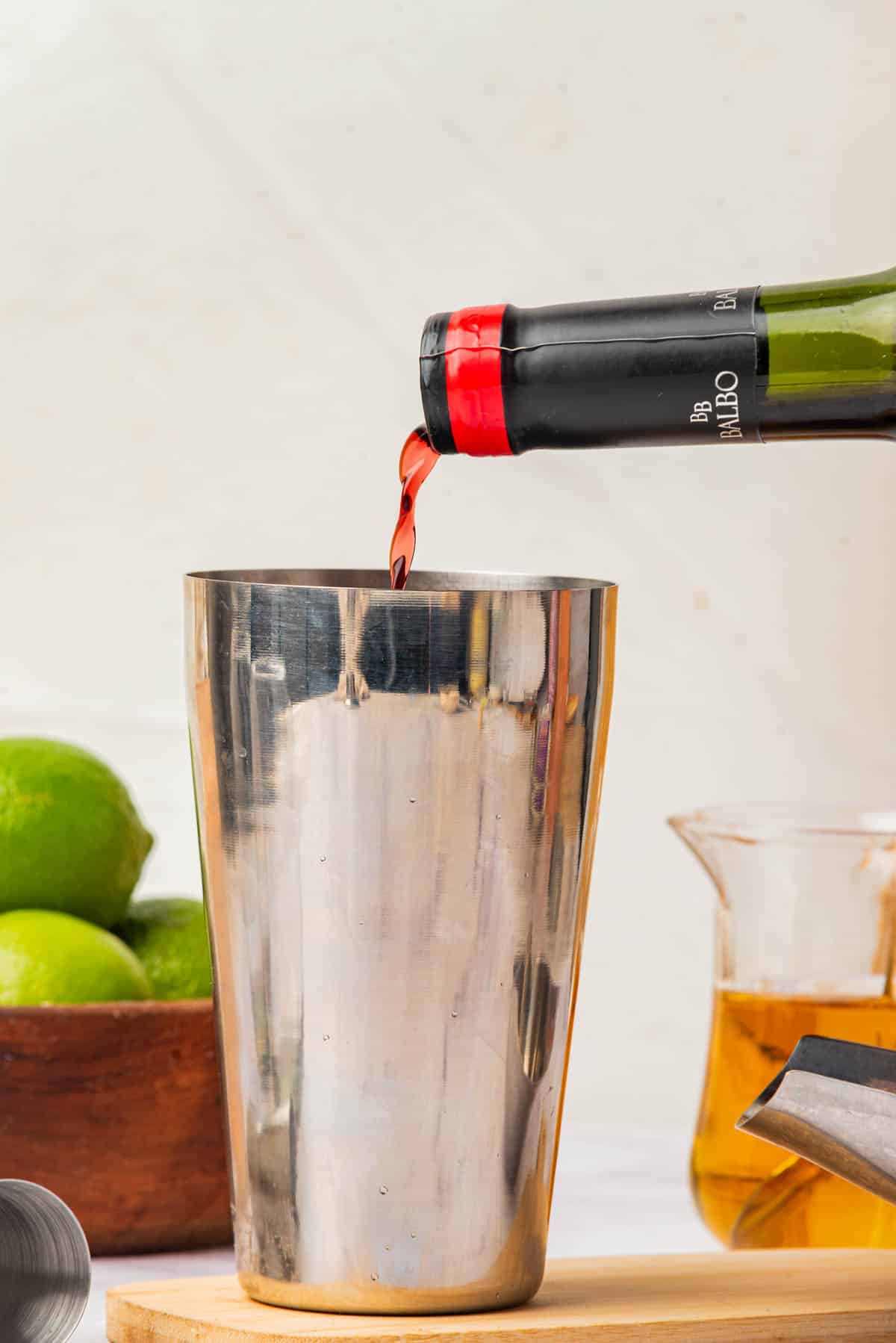 Pouring red wine into a cocktail shaker.