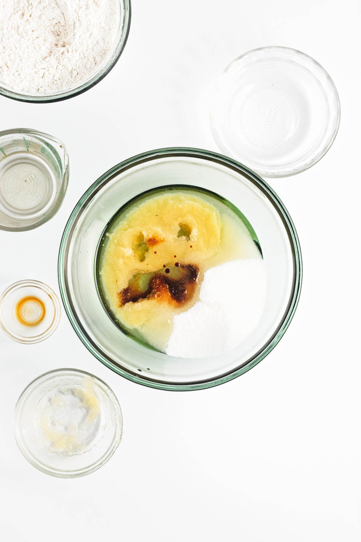 Oil, sugar, applesauce, and vanilla, and flour mixture in a glass bowl.