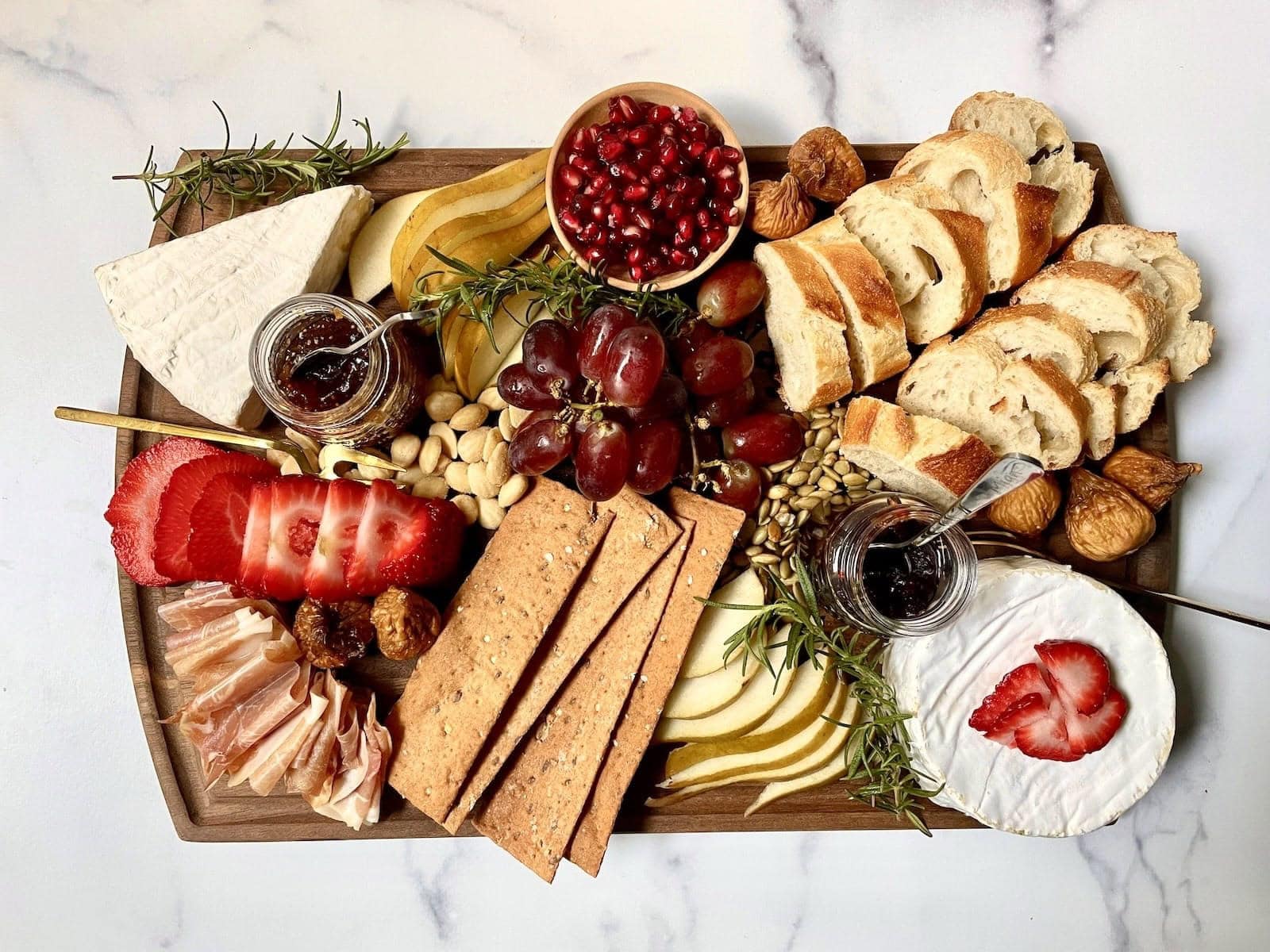 wood board with brie cheese and condiments.