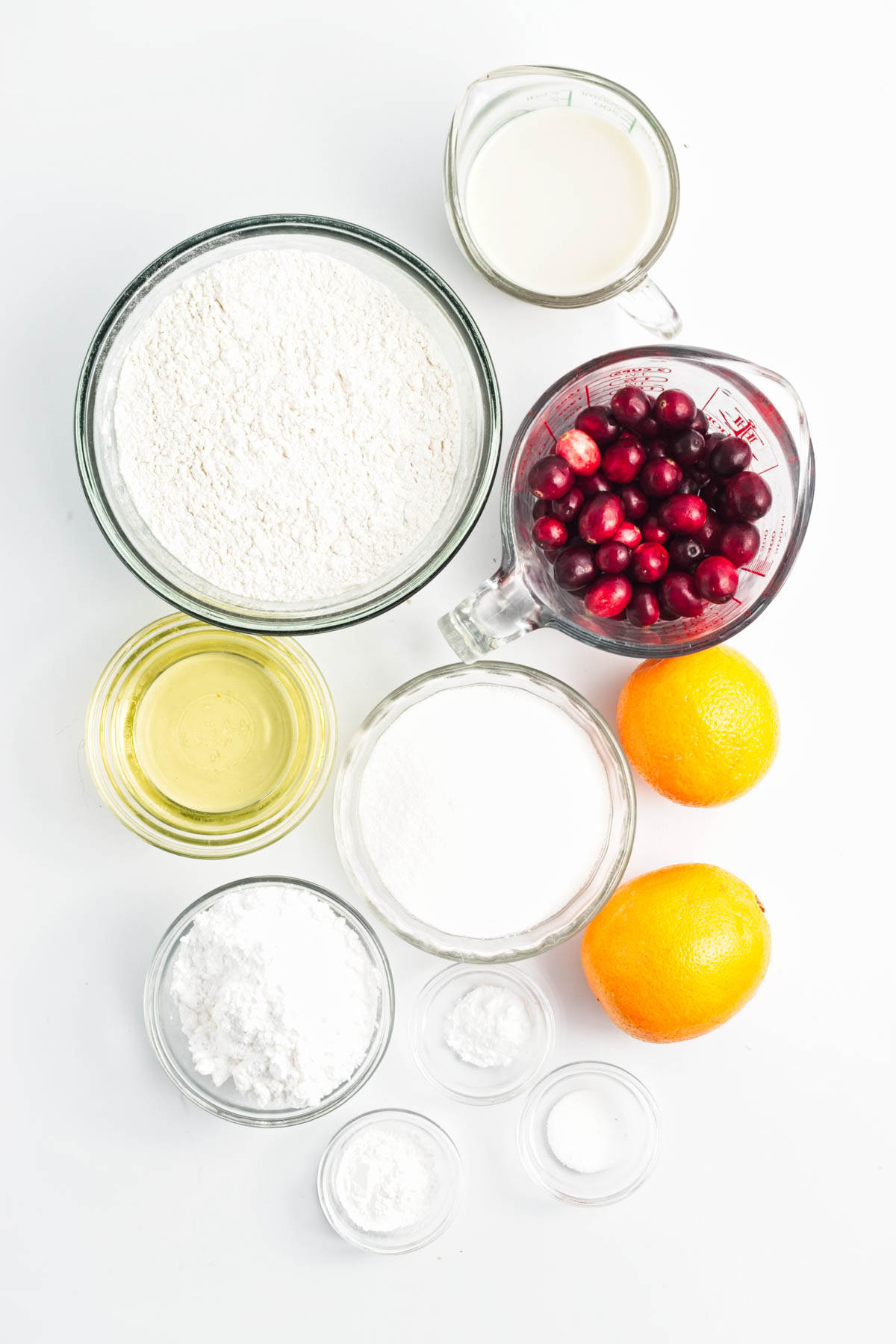 Flour, baking powder, baking soda, cranberries, oranges, oil, milk, sugar, and salt.