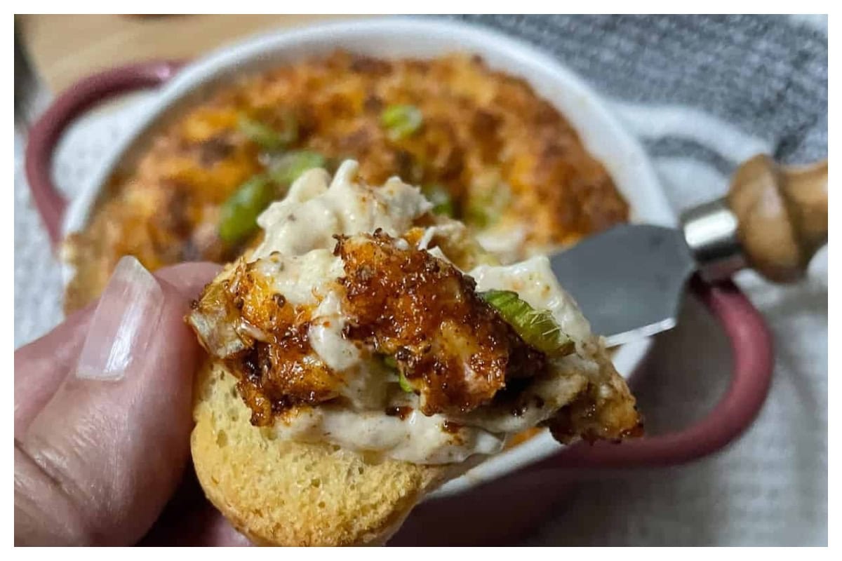 Maryland crab dip bring scooped out of bowl.