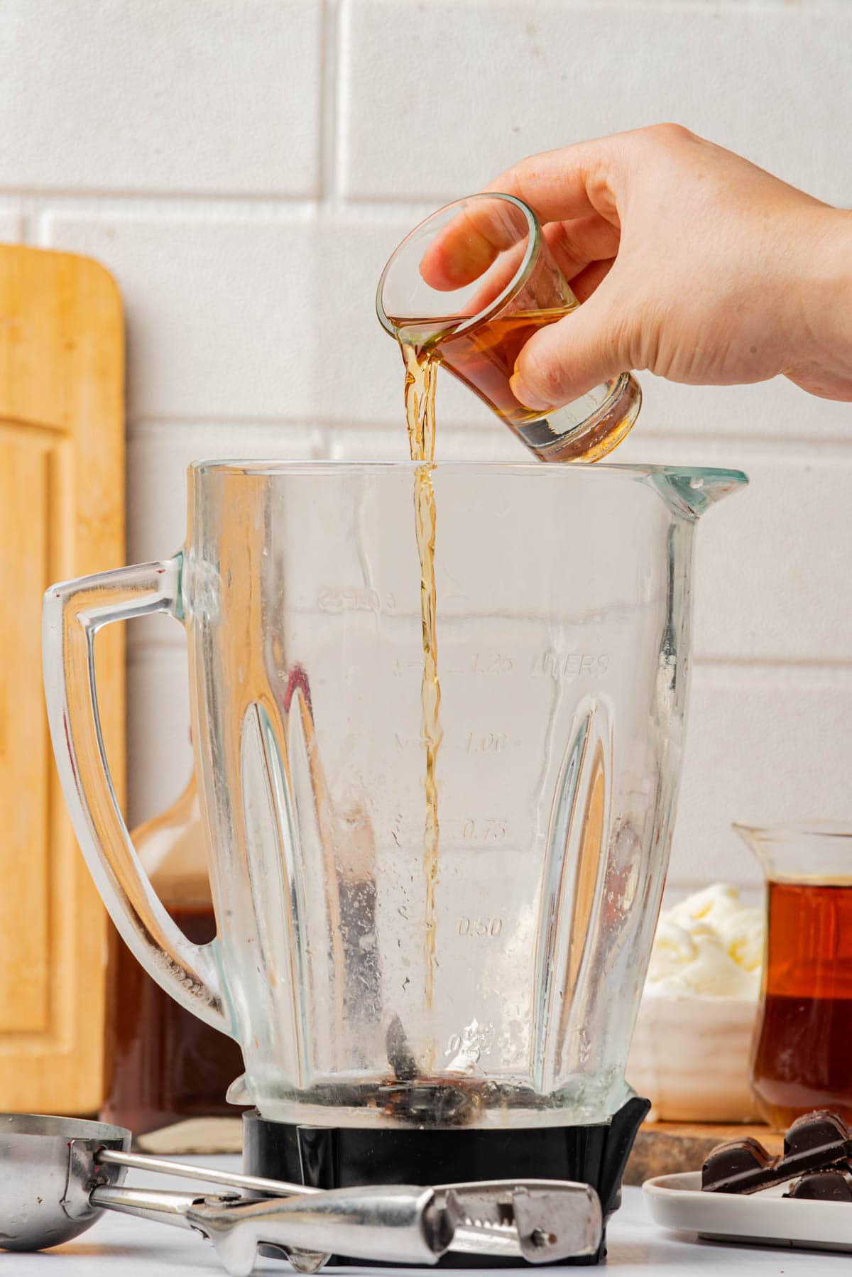 Pouring brandy into a blender.