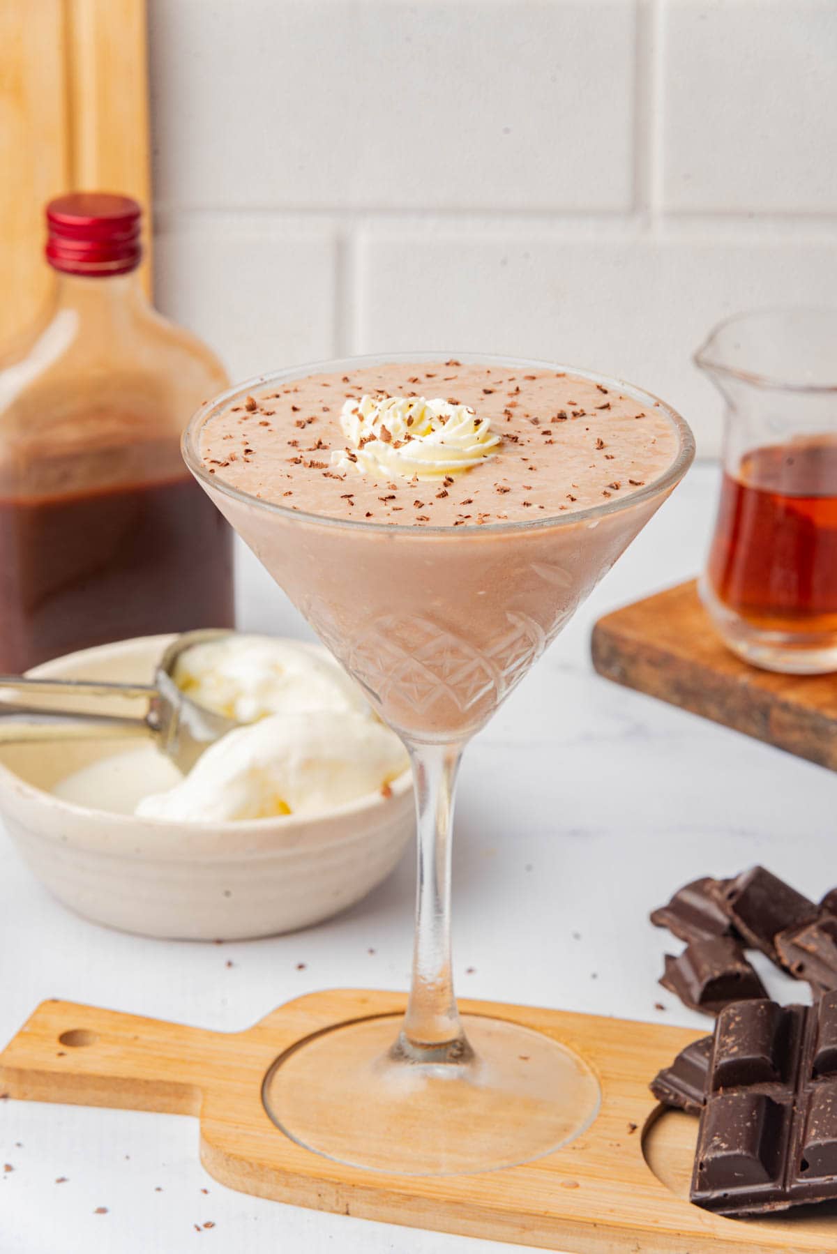 Frozen chocolate drink with shaved chocolate and whipped cream in a tall cocktail glass.