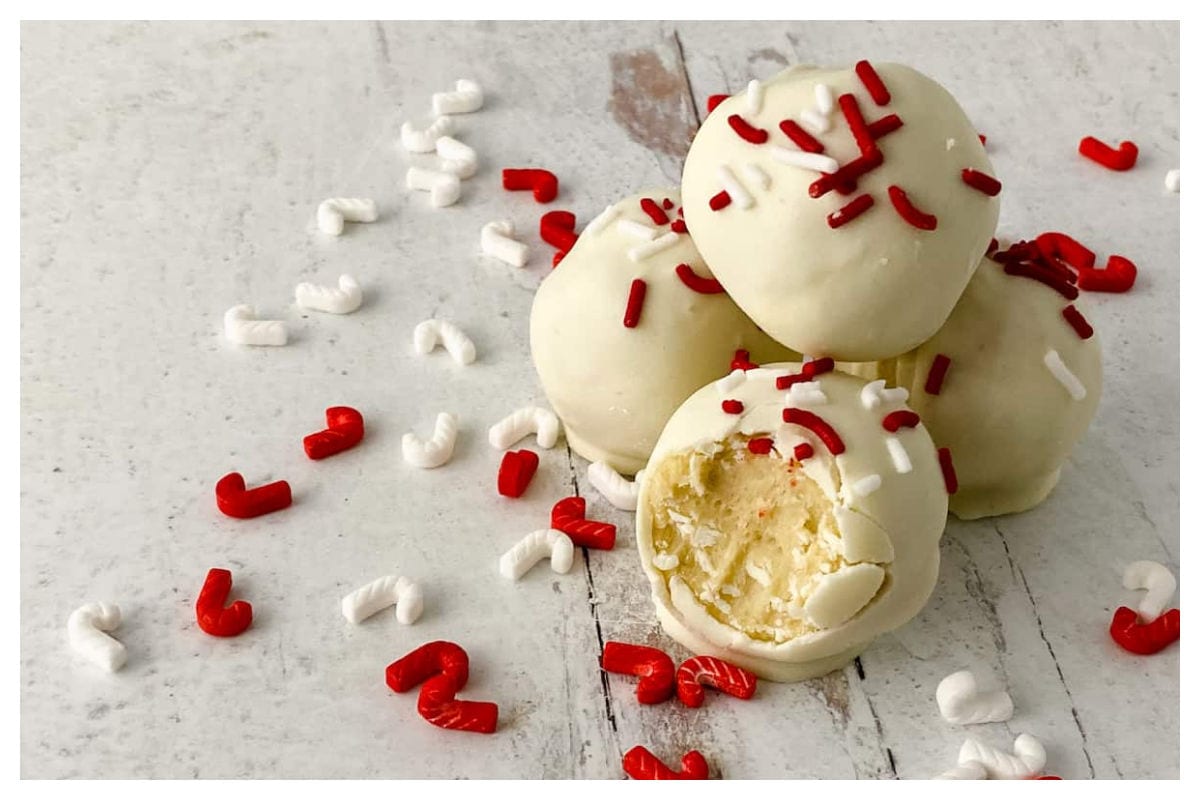 Balls of cookie dough dipped in white chocolate and sprinkled with candies.