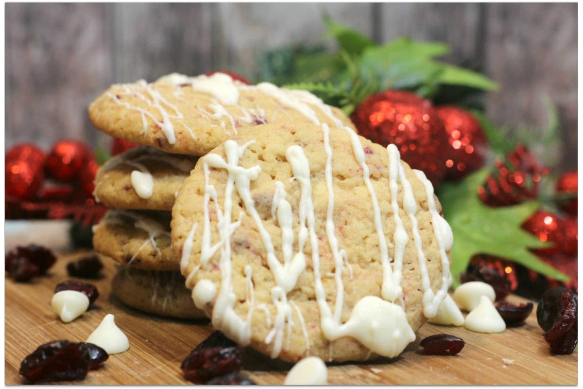 Cranberry cookies drizzled with white chocolate in front of holiday decor.