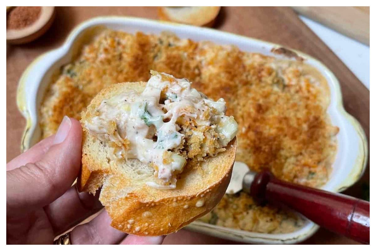 Shrimp dip casserole under a cracker with shrimp dip on top.