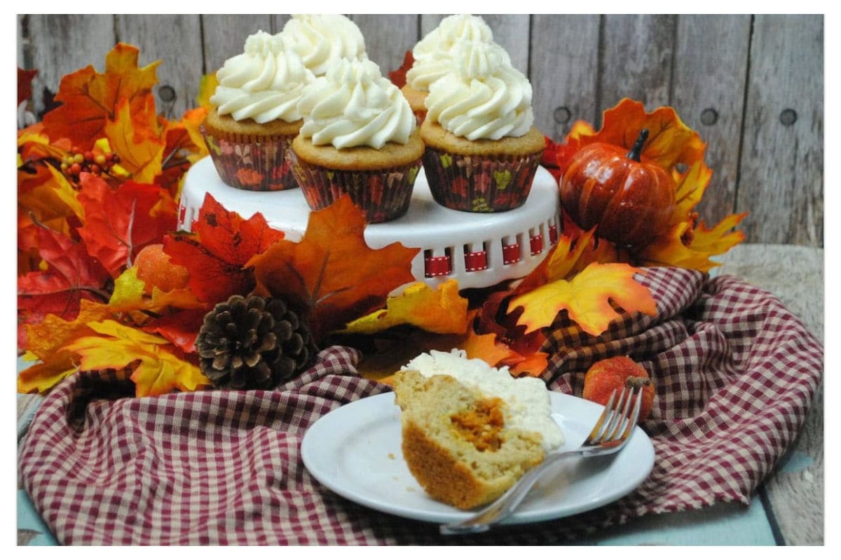 Cupcakes with a pumpkin pie center on a festive table.