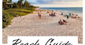 Beach with people playing volleyball in the sand.