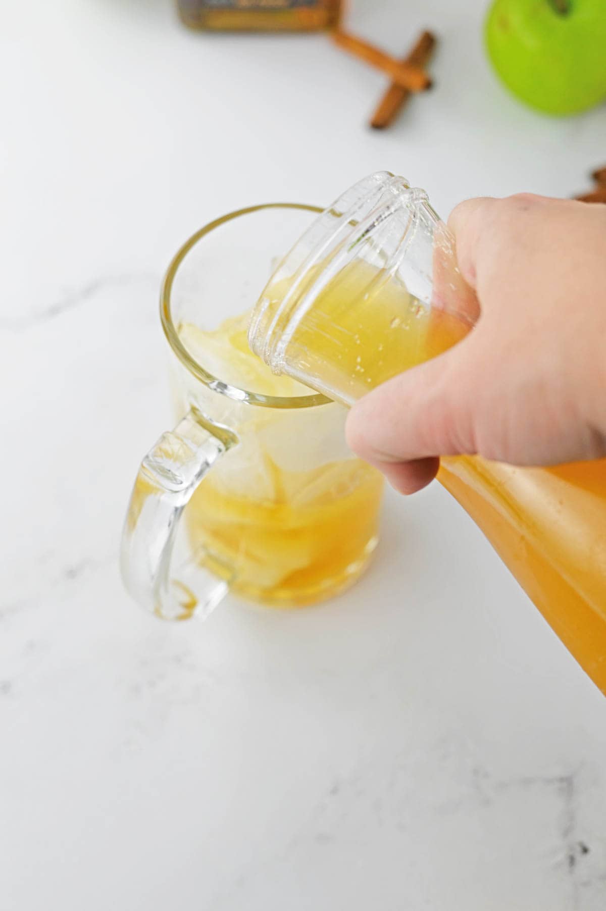 Pouring apple cider into glass.