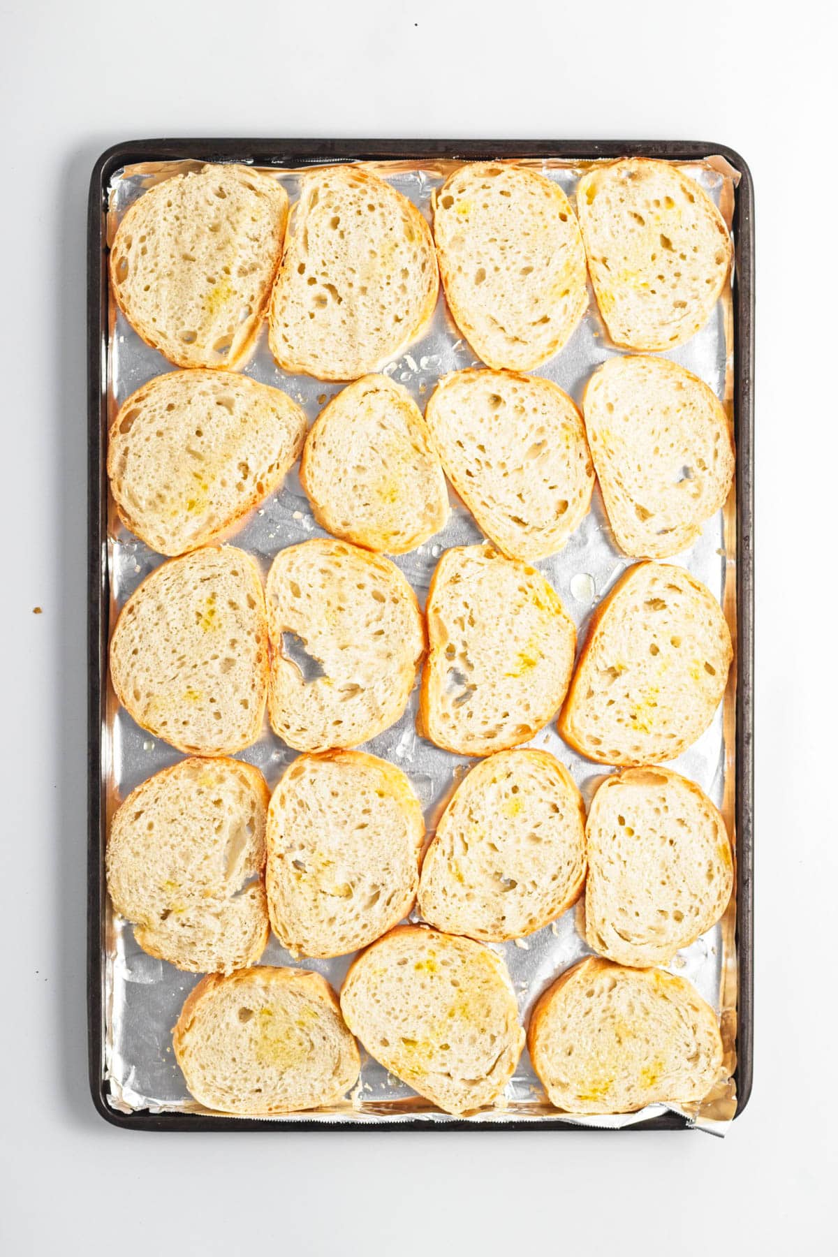 Sliced bread on a baking sheet.