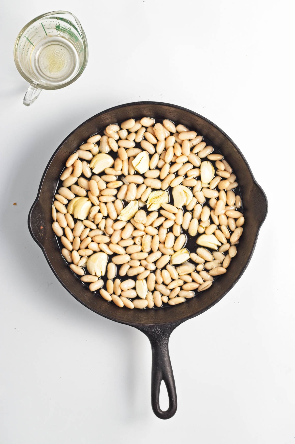 Beans, garlic, and olive oil in cast iron pan.