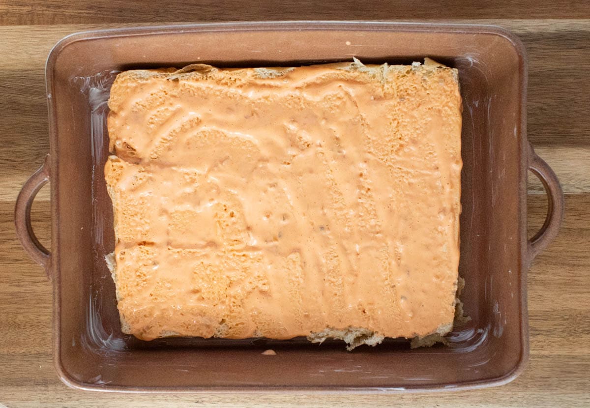 Bottoms of rolls in a greased baking dish with thousand island dressing.