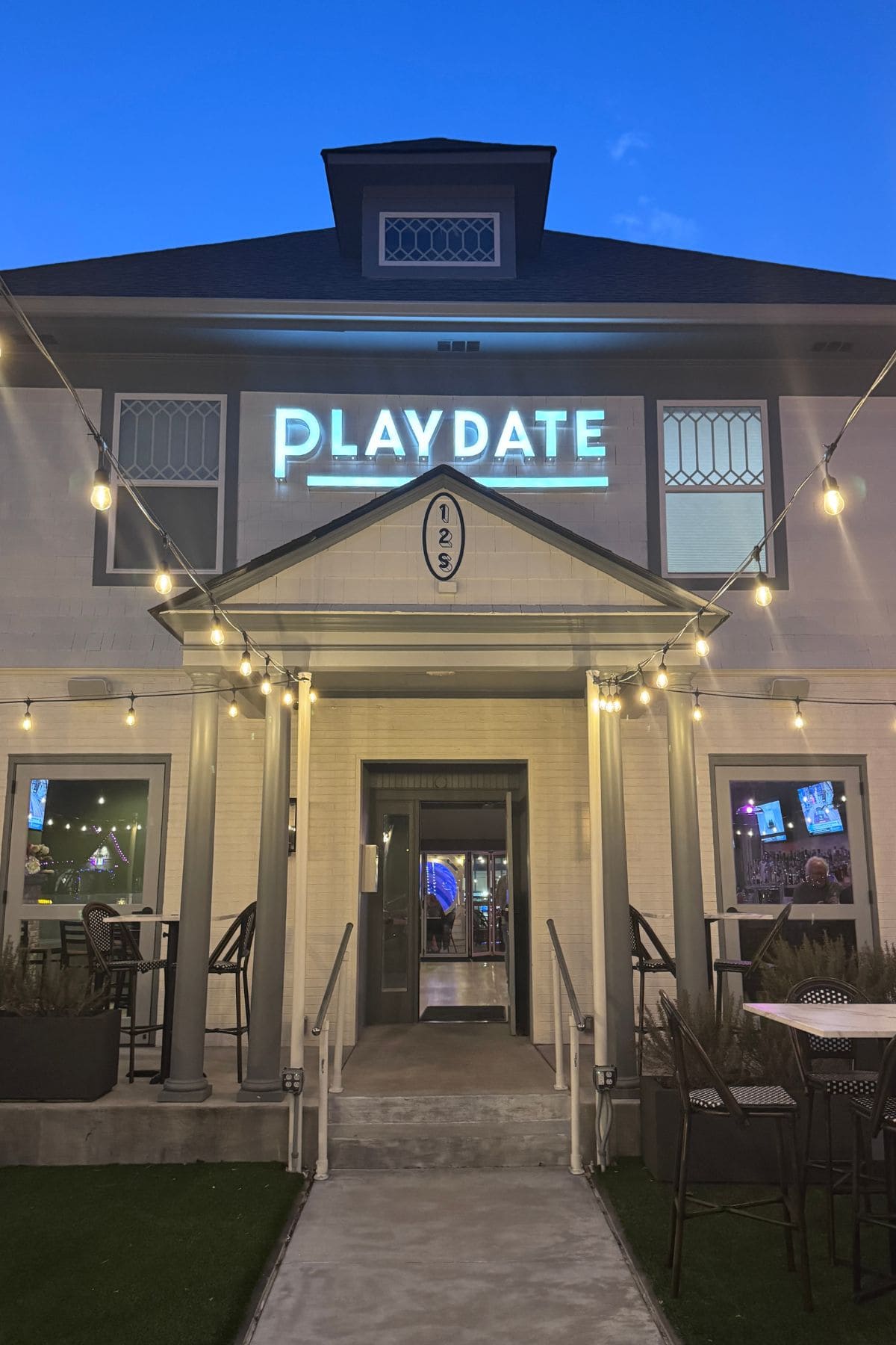 White building with neon sign saying Playdate.