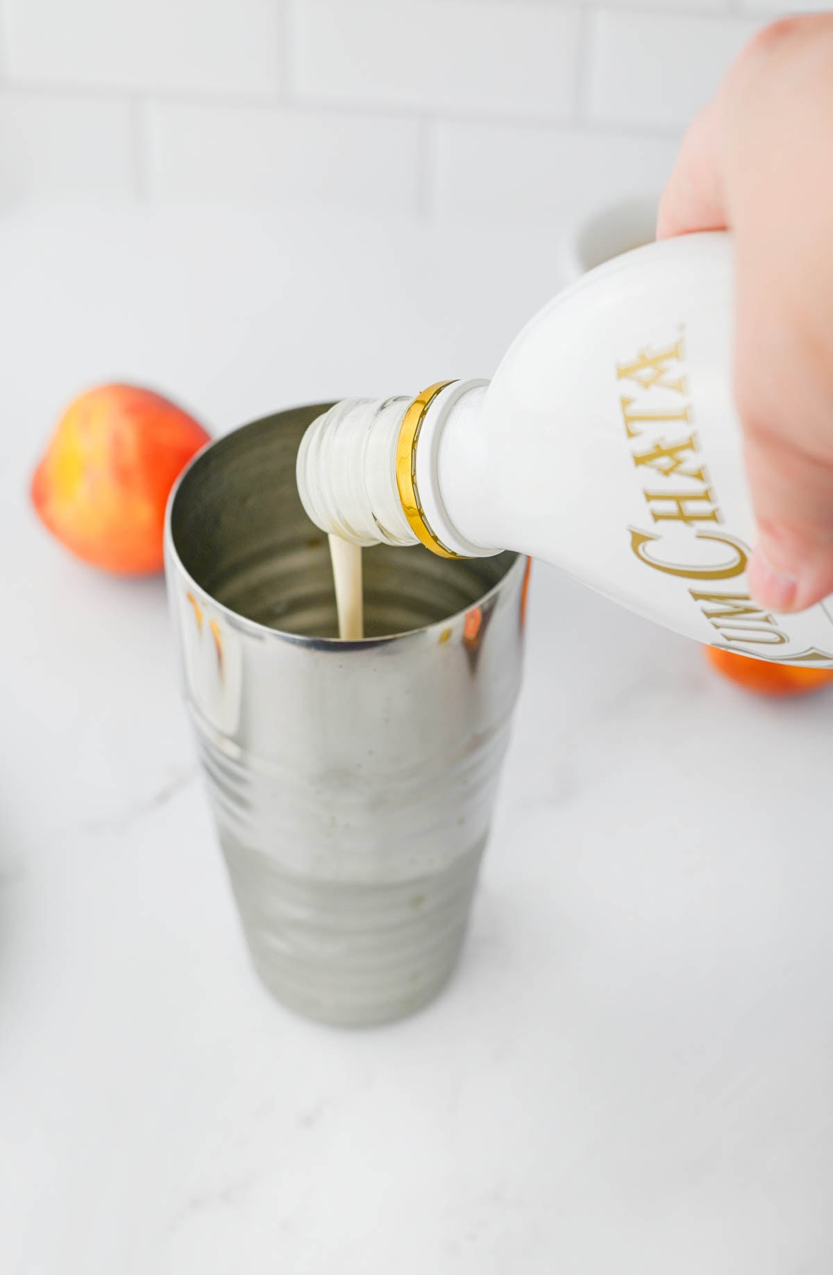 Pouring Rumchata into a cocktail shaker.