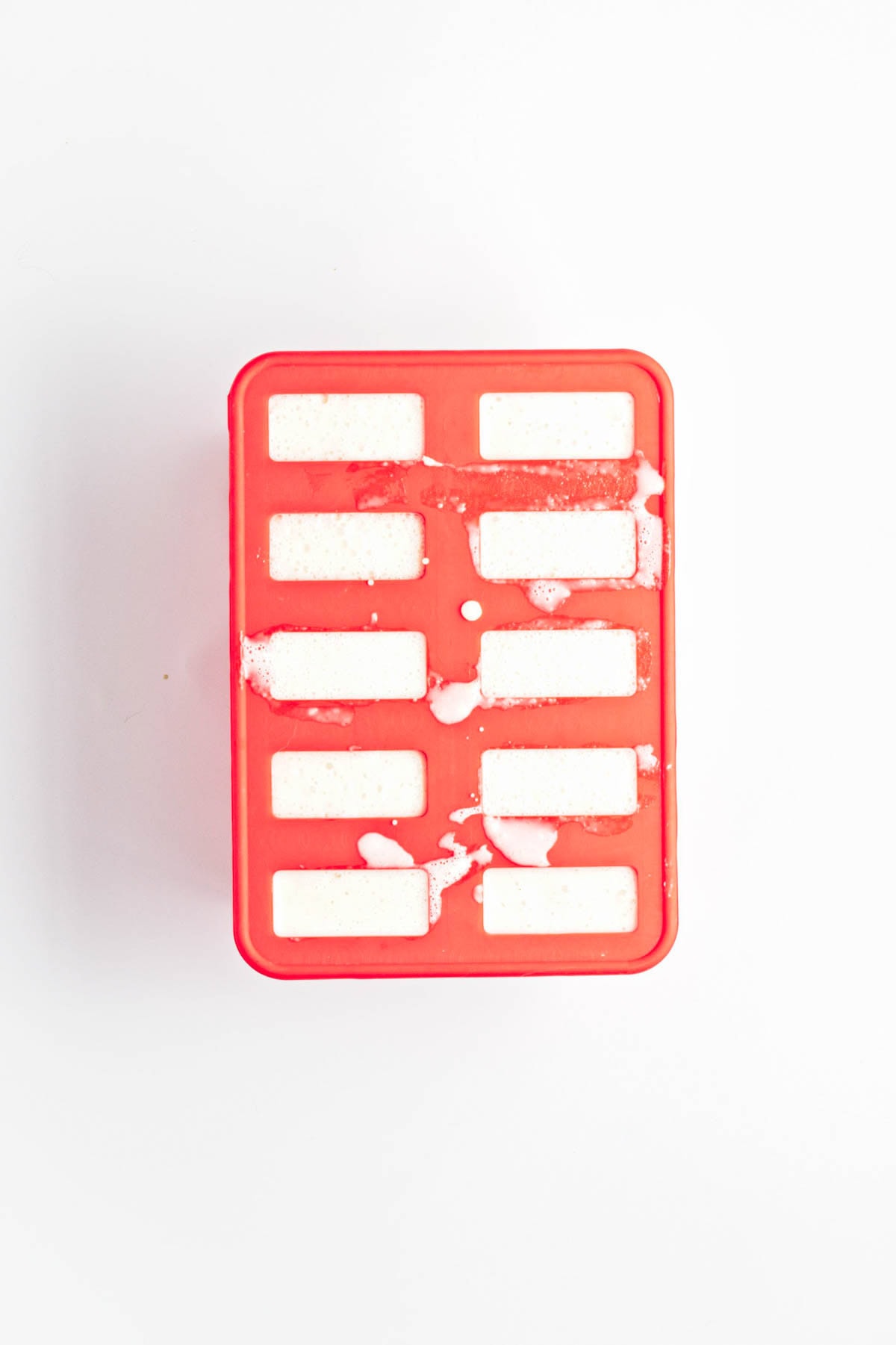 White liquid in popsicle molds.