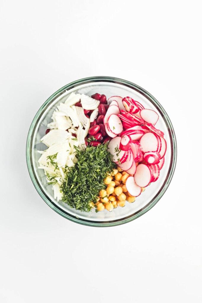 Bean salad ingredients in a glass bowl.