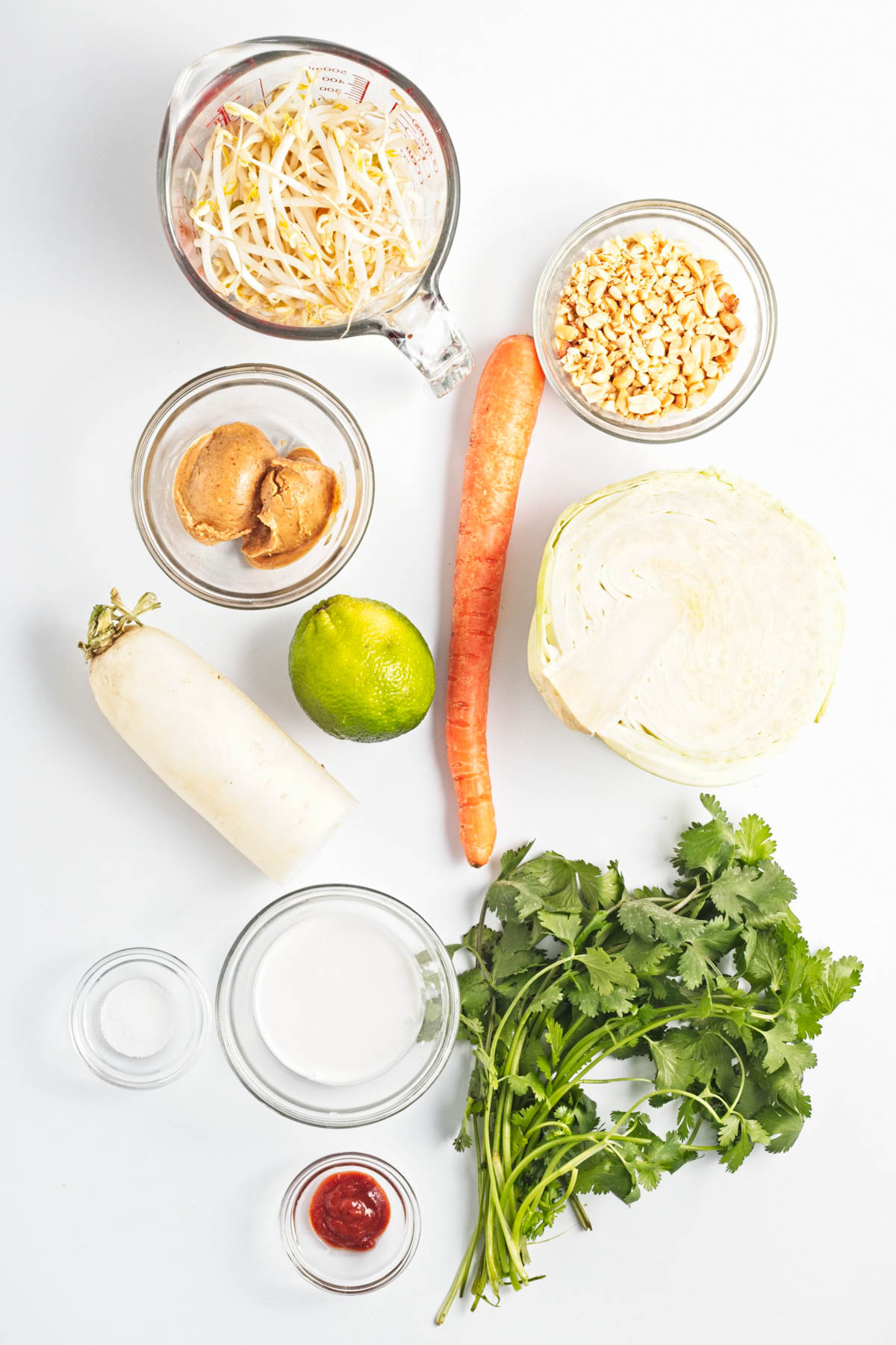 Vegetables to make cole slaw on a white counter.