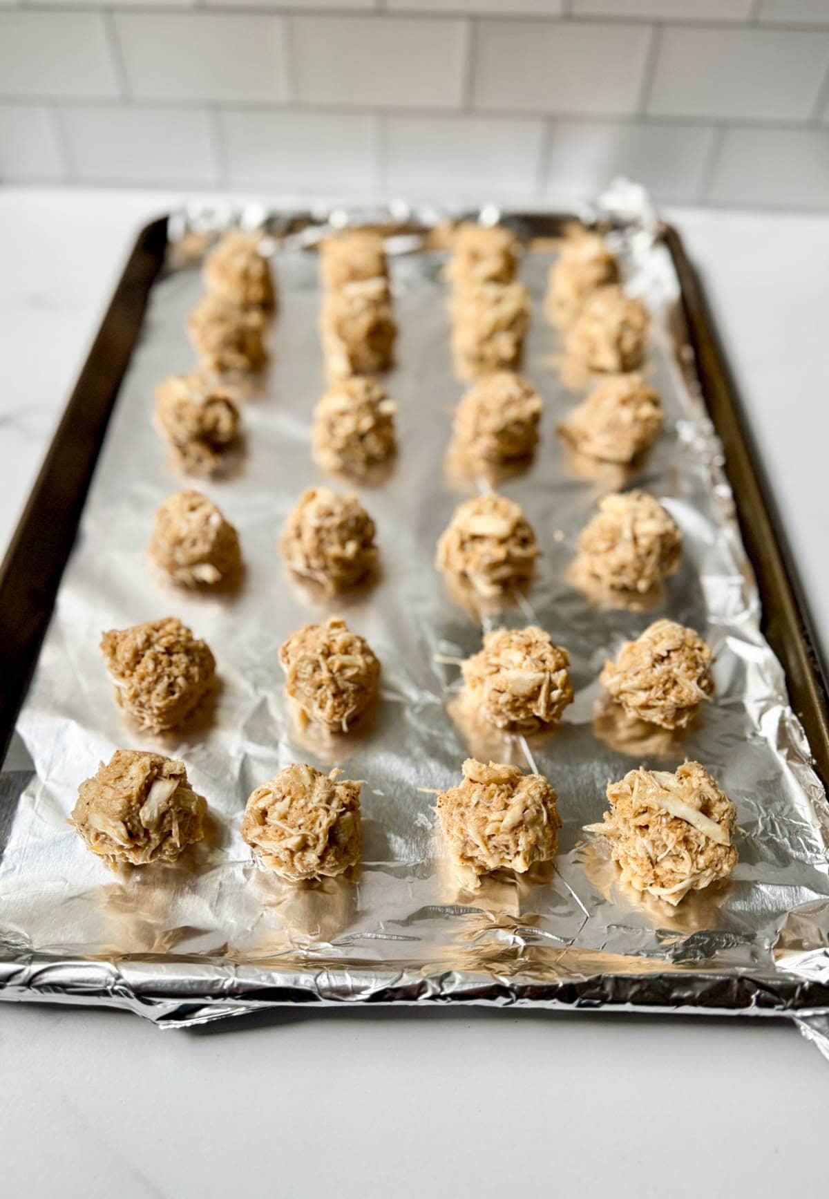Crab balls before baking on aluminum foil lined baking sheet.