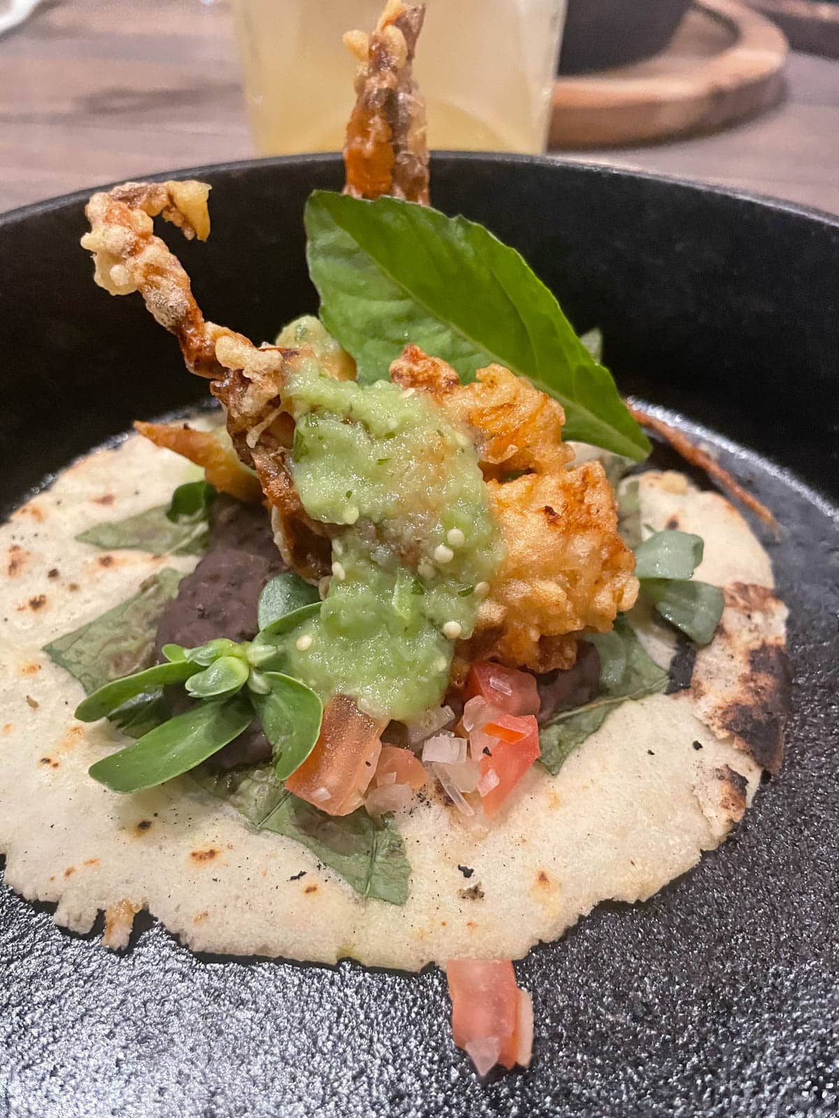 Fried soft shell crab on tortilla with basil, tomato, black beans, and green sauce.
