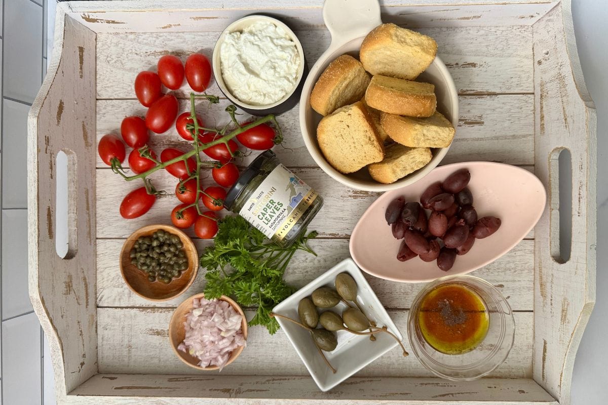 White tray with ingredients for Dakos salad.
