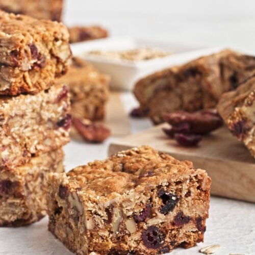 Oatmeal bar squares on white counter with cutting board.