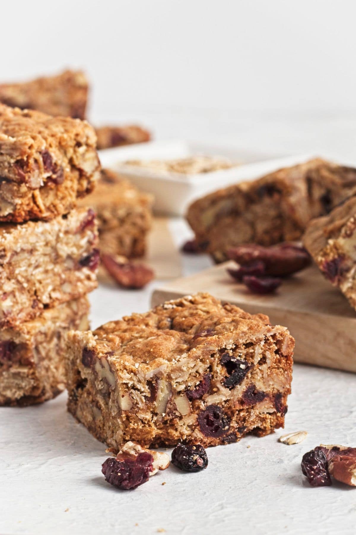Oatmeal bar squares on white counter with cutting board.