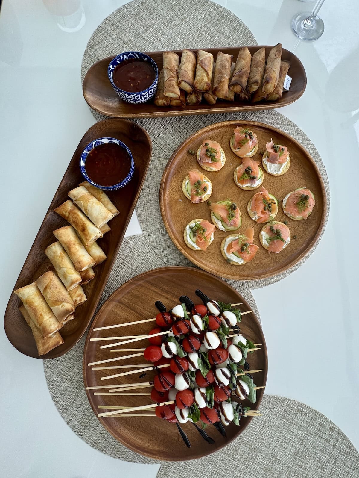 Plates of food on placemats on a white table.