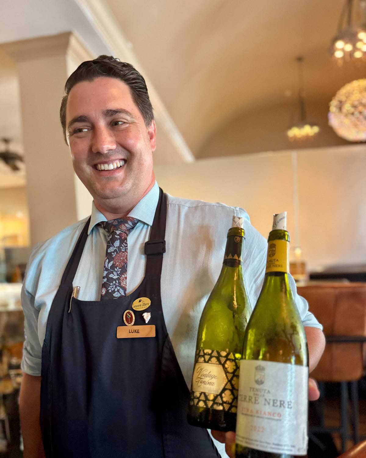 Man holding two bottles of wine.