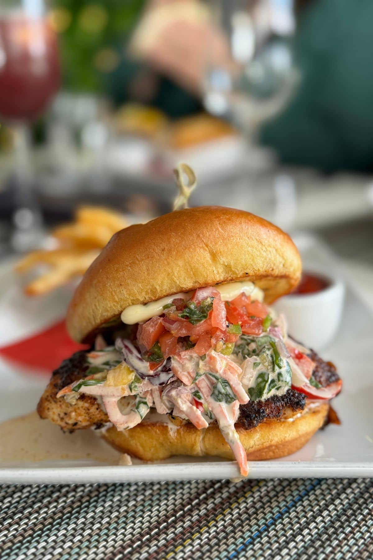Grouper sandwich with slaw on a bun on a white plate.