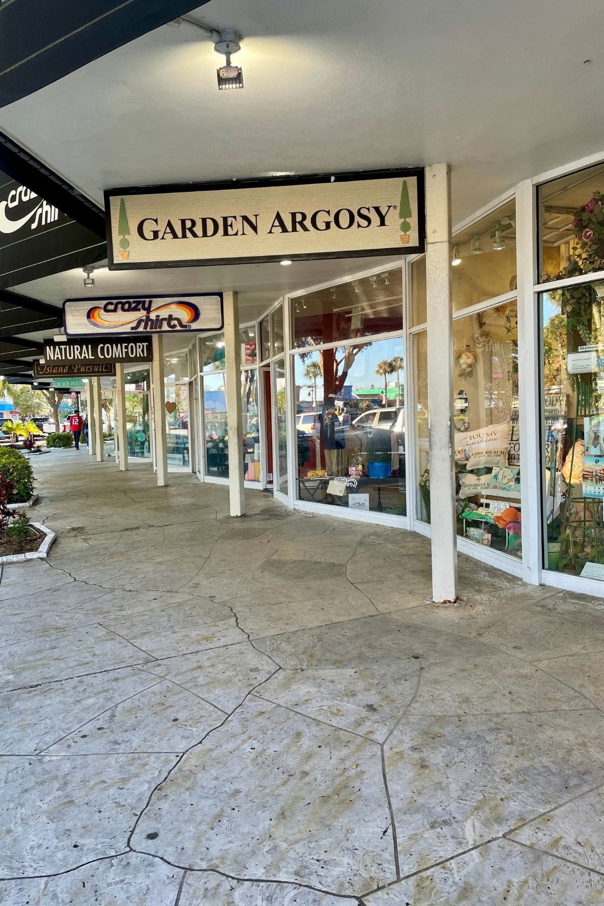 Shops along a walkway with signs overhead.