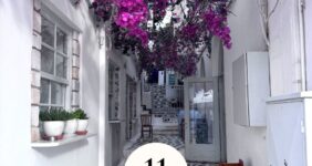 Cobblestone walkway in Naxos with pink flowers above on Pinterest graphic.