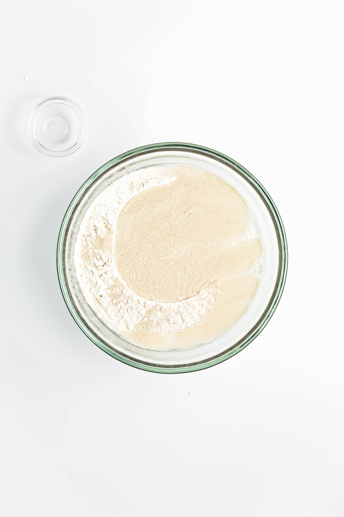 Water, flour and yeast in a glass bowl.