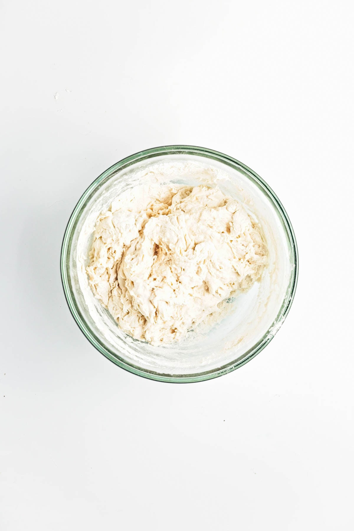 Rough dough in a glass bowl.