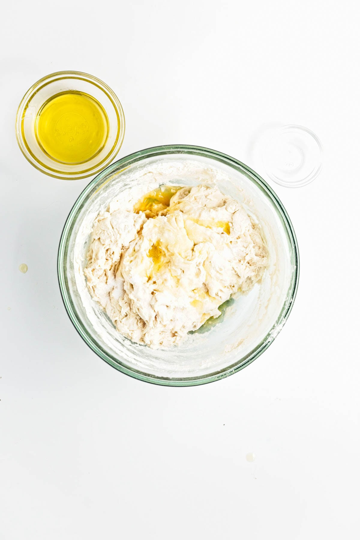 Rough dough in a glass bowl withh olive oil.
