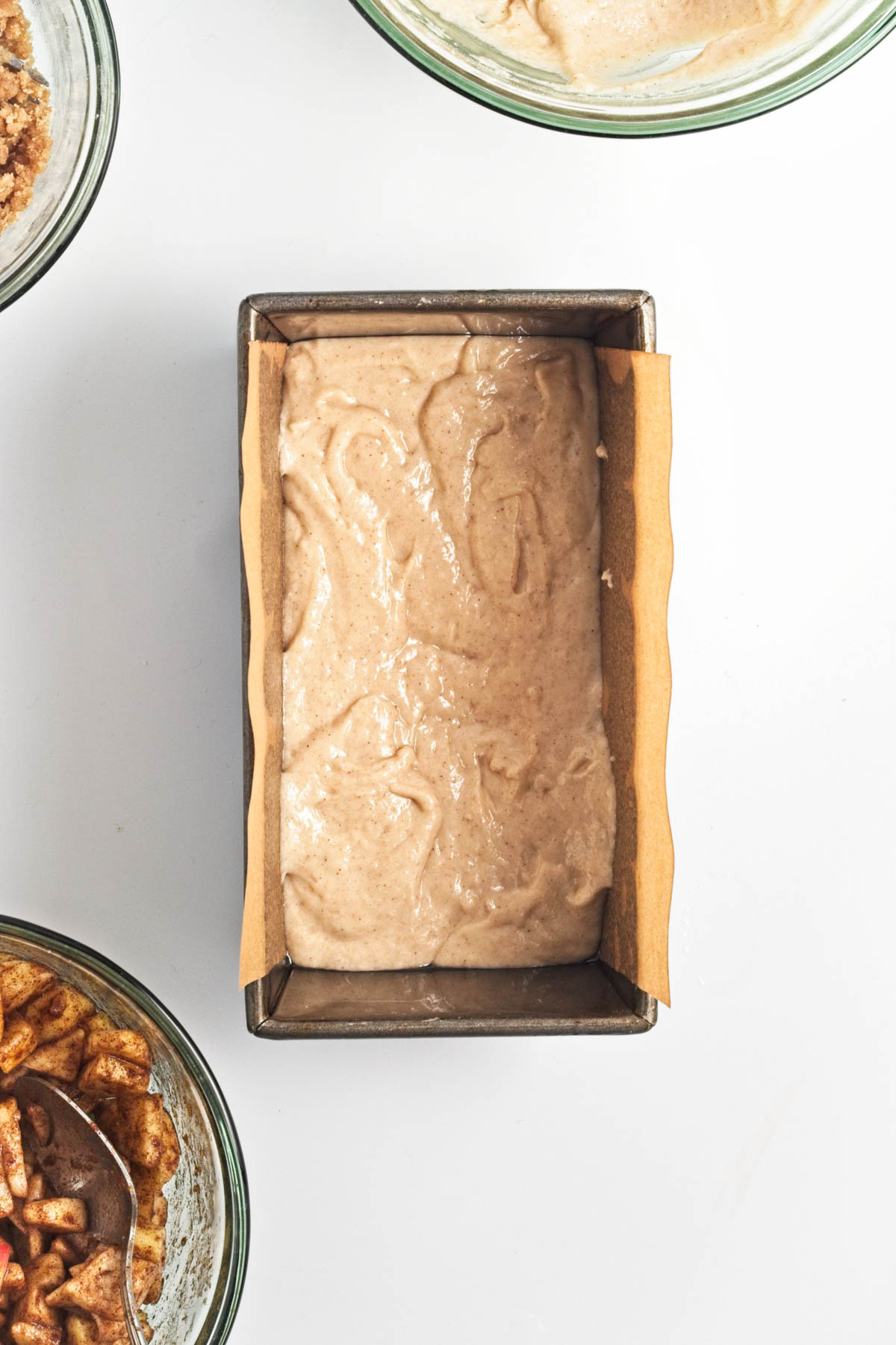 Batter in loaf pan with parchment paper underneath.