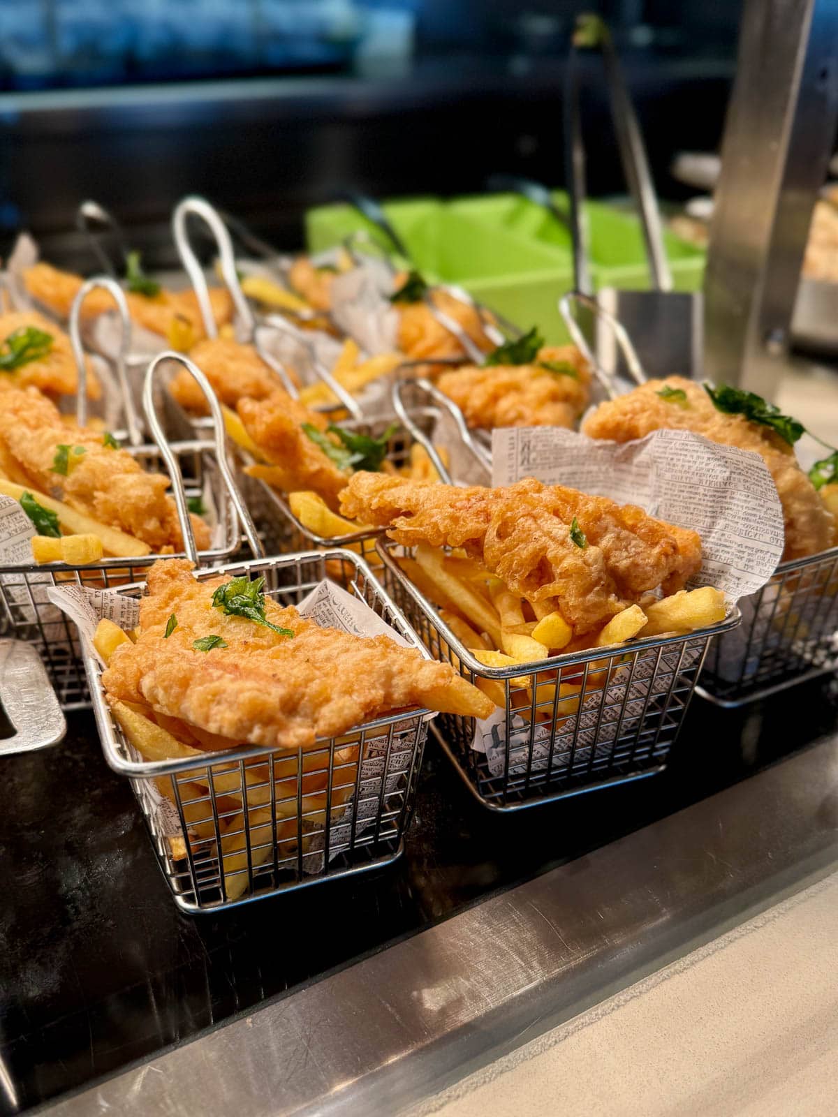 Fish and chips in fryer-like baskets.