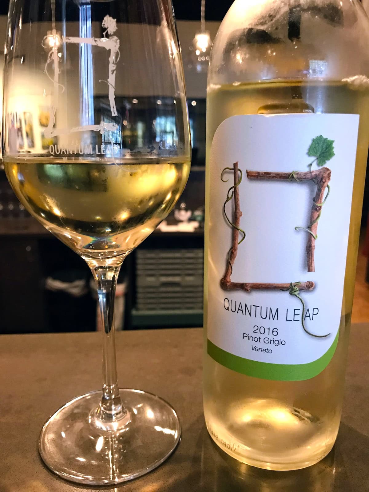 Glass of white wine next to the bottle.