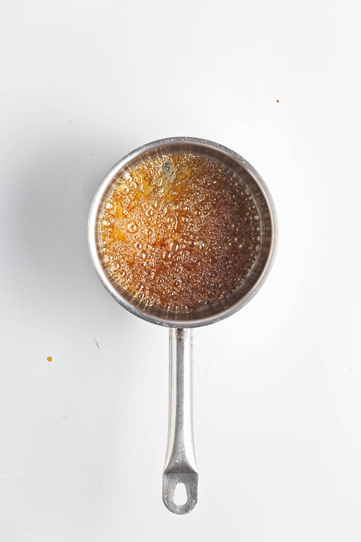 Golden liquid bubbling in an aluminum pan.