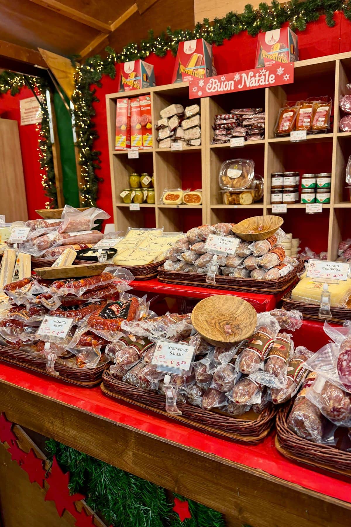 Market stall decorated for Christmas and showcasing German food items.
