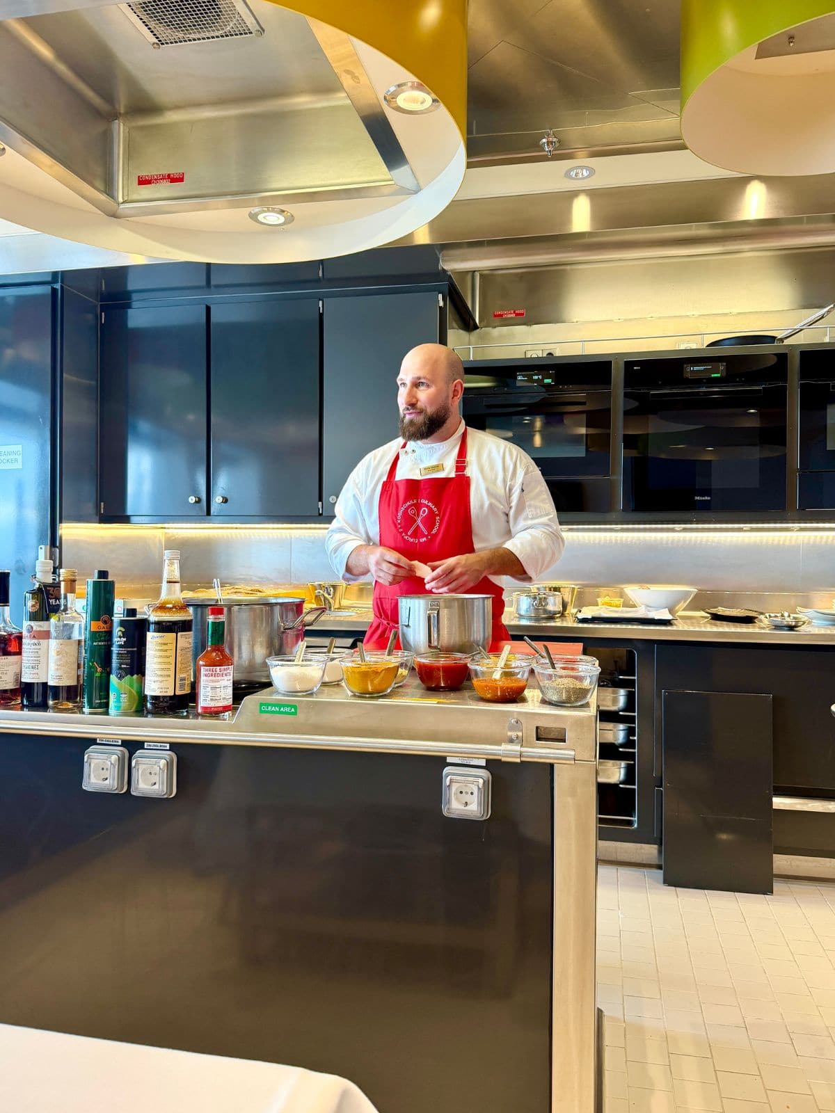 Man in red apron teaching a cooking class.