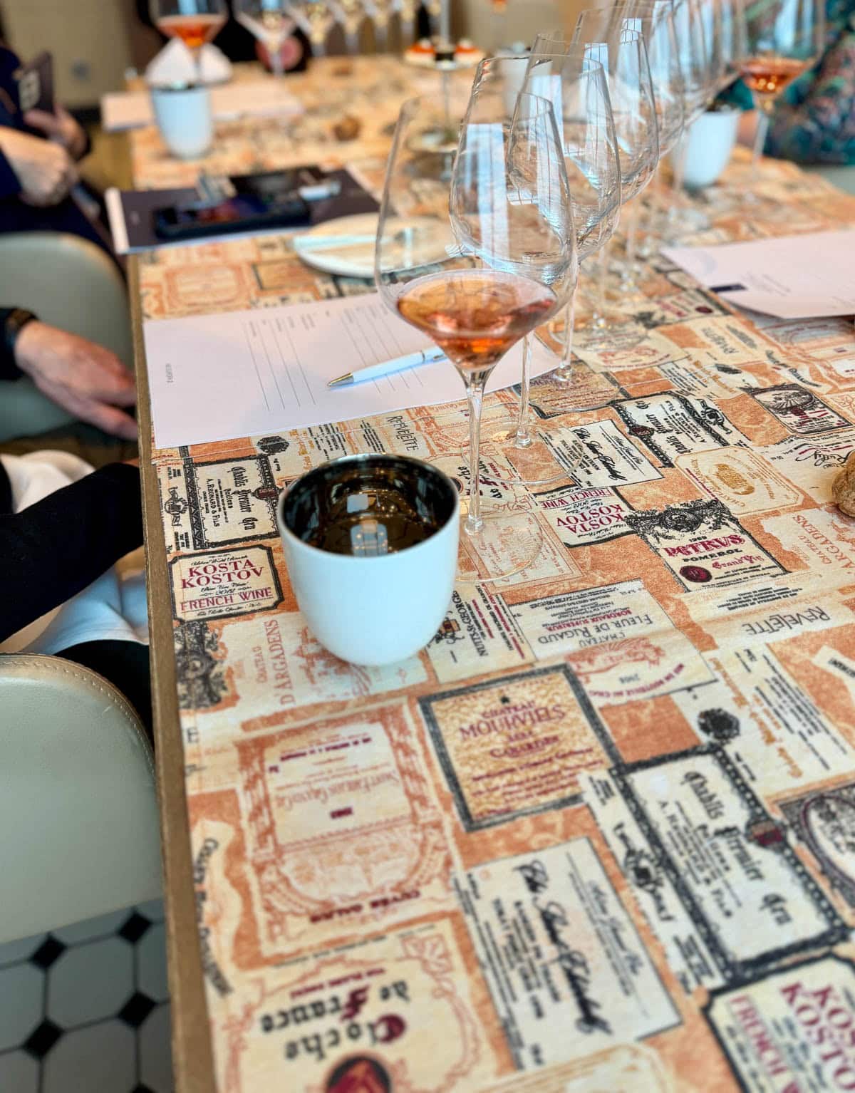 Glasses of champagne on a table of wine labels.