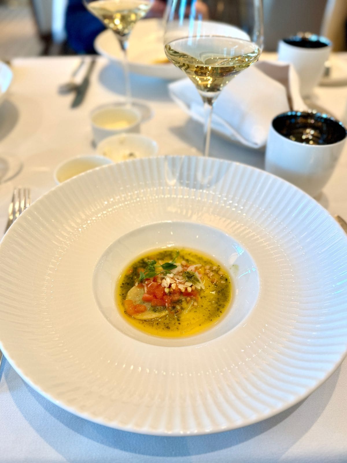 Ravioli with a butter sauce in a white bowl.