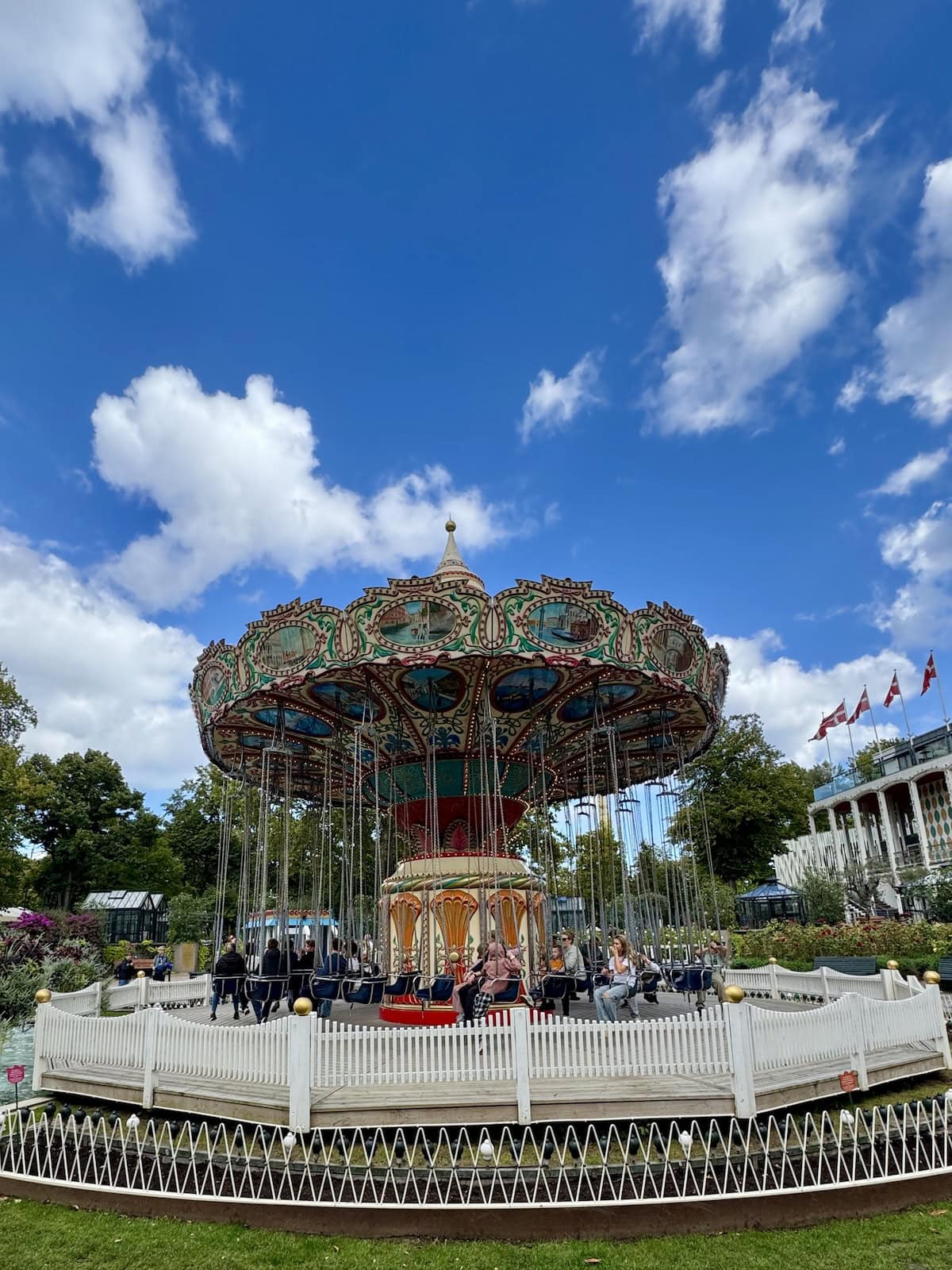 A colorful carousel with swings for seating.