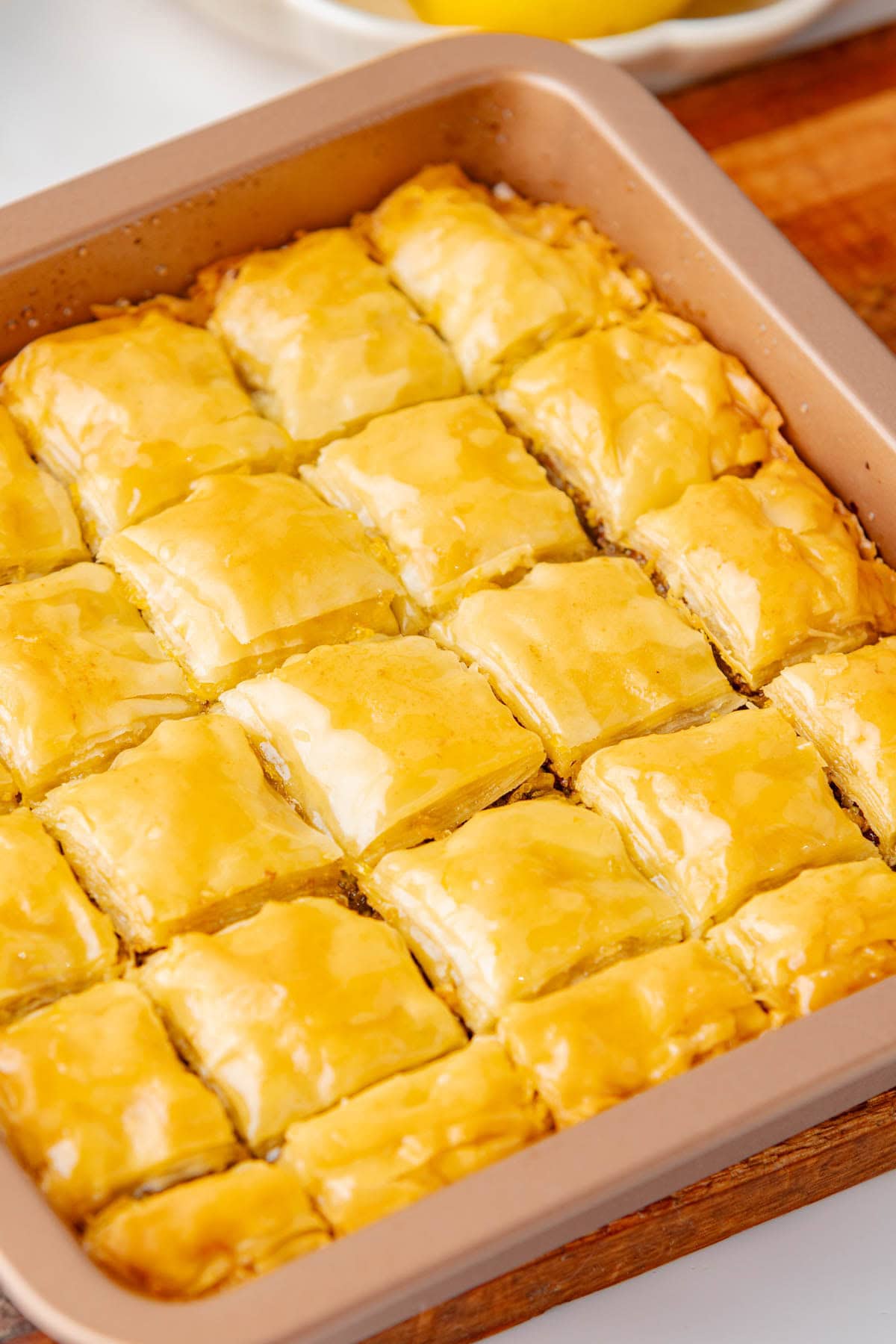 Close up of Baklava in a square baking pan cut in small squares.