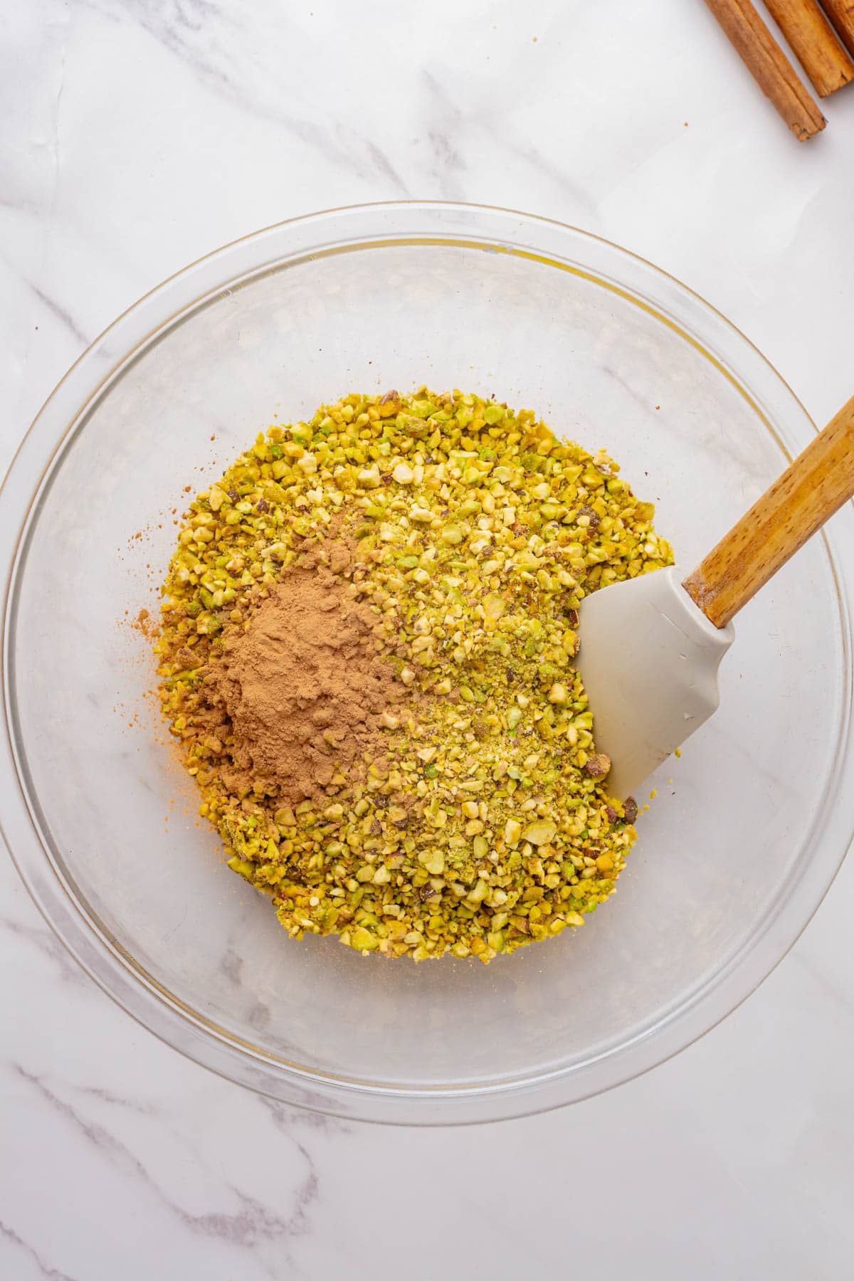 Crushed pistachio nuts with cinnamon in a glass bowl.