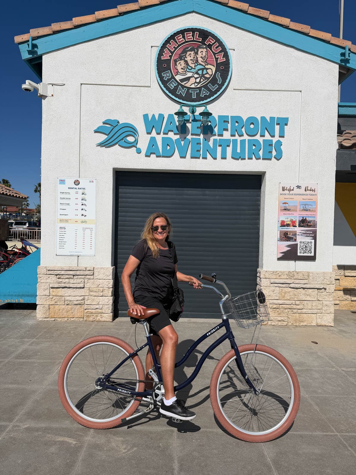 Woman on bike in front of bike rental shop.