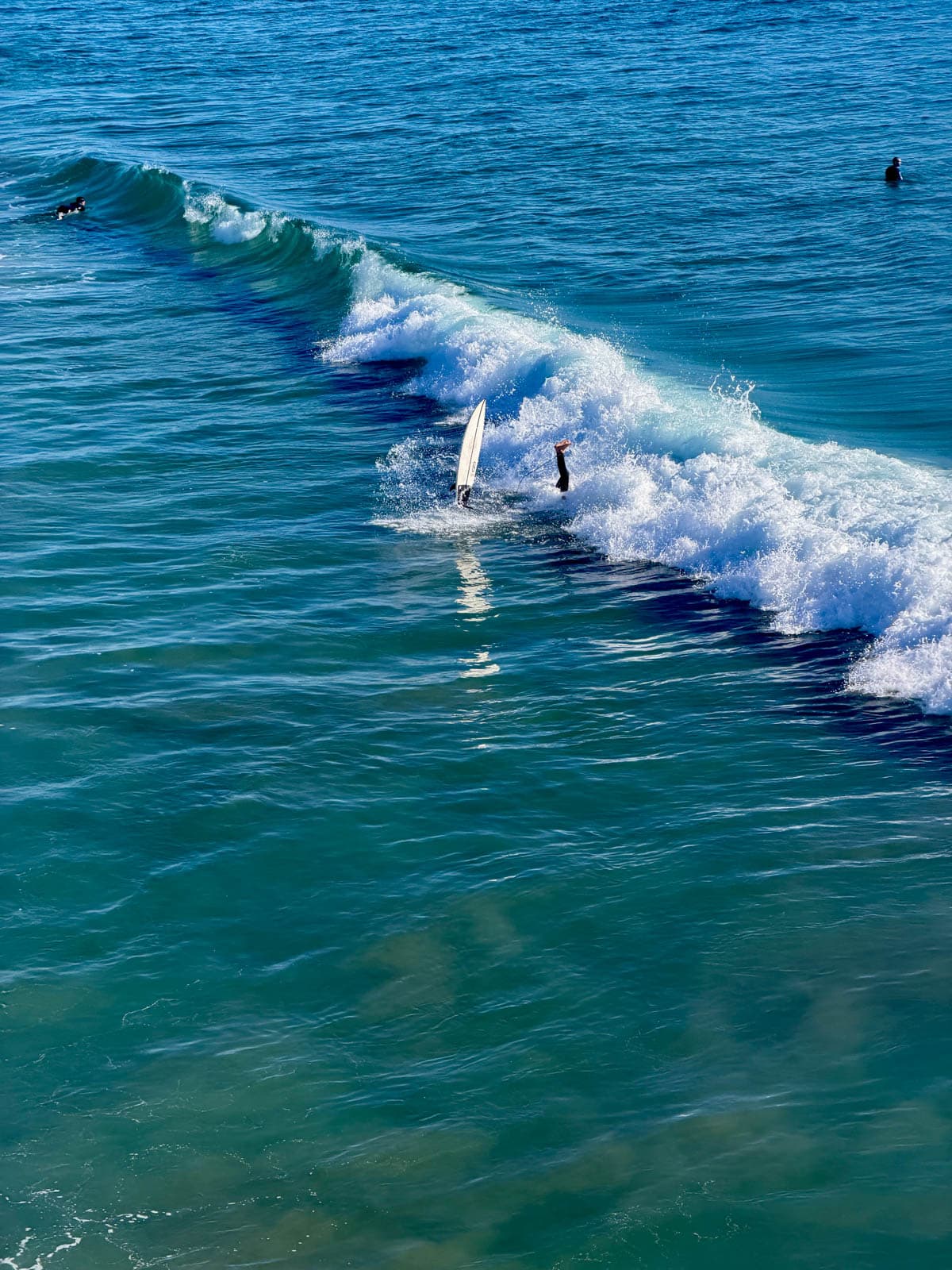 Surfers on a wave at Huntington Beach in California.