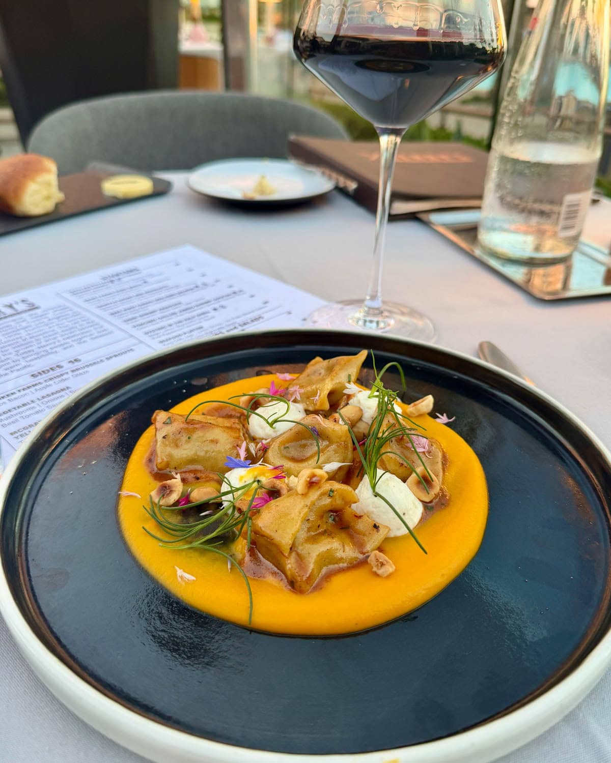 Butternut squash puree topped with pasta, cheese, hazelnuts, and microgreens.
